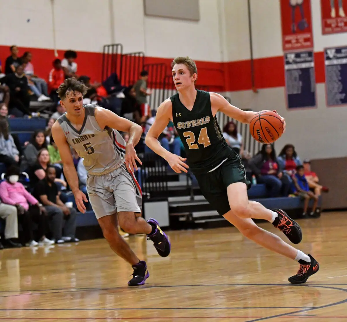 Rachel Stuart / Daily Sun  -  Sam Walters{cq} (24), right, of The Villages High School, dribbles the ball down the court as Tristan Unold{cq} (5), of Vanguard High School, tries to stop him during the season opener on Monday, Nov. 22, 2021, at Vanguard High School in Ocala.