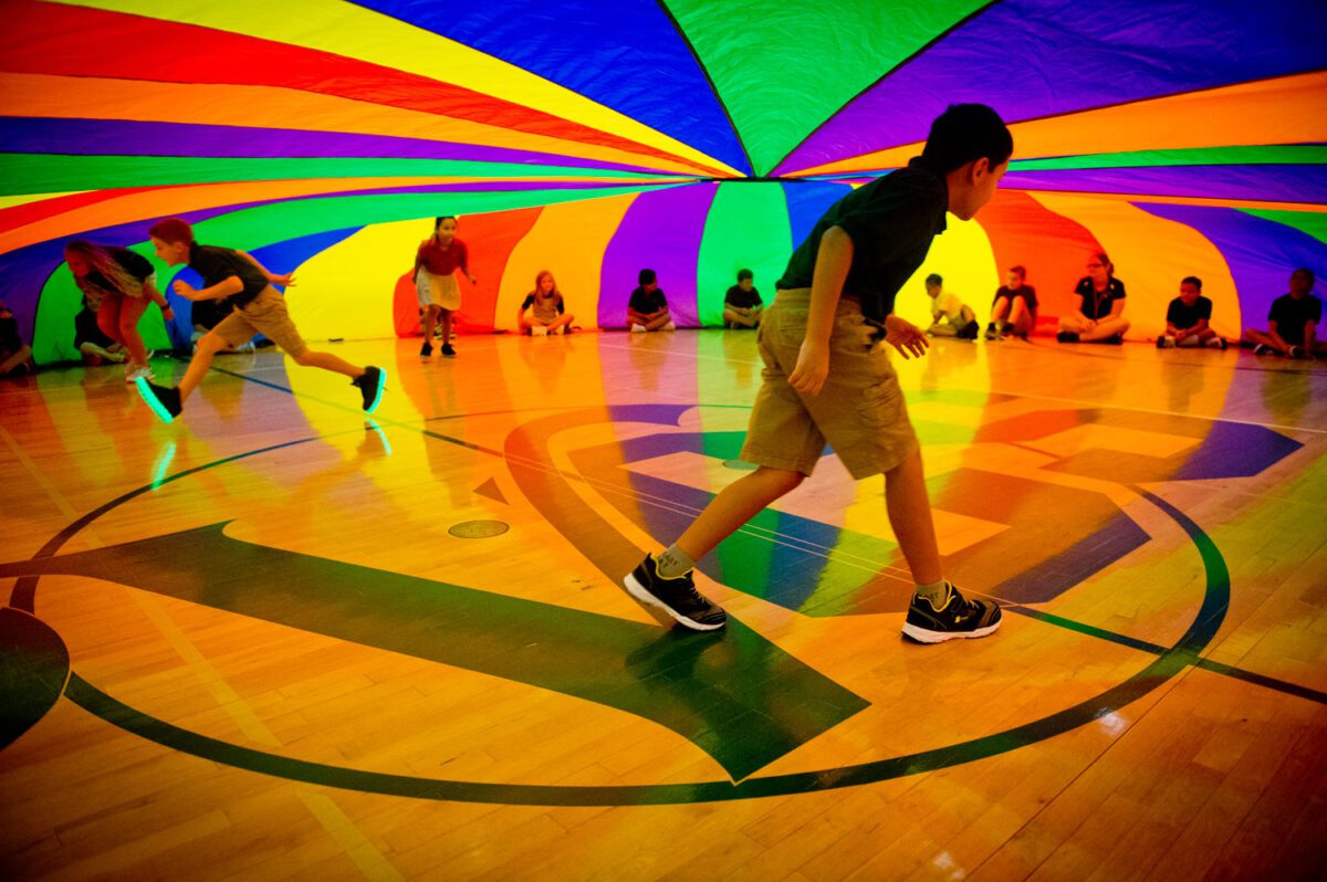 Erin Williams / Daily Sun - Fourth graders walk underneath a parachute in P.E. during the first day of school on Thursday, Aug. 9, 2018, at The Villages Charter 4th and 5th Grade Center.