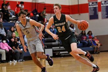 Rachel Stuart / Daily Sun - Sam Walters{cq} (24), right, of The Villages High School, dribbles the ball down the court as Tristan Unold{cq} (5), of Vanguard High School, tries to stop him during the season opener on Monday, Nov. 22, 2021, at Vanguard High School in Ocala.